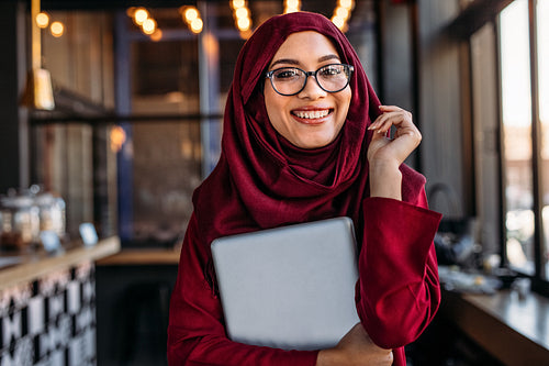 Smiling businesswoman in hijab at coffee shop