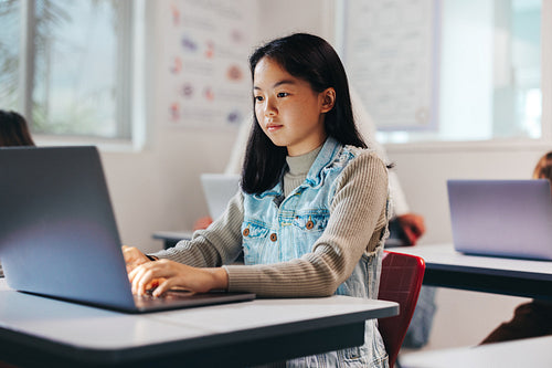Exploring the digital world: Girl programming on a laptop in a coding class