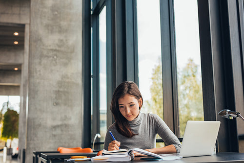 Young female student studying in library