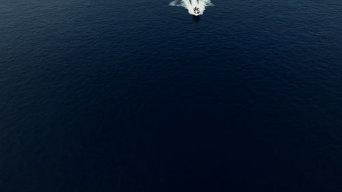 Boat speeding across the deep blue ocean water