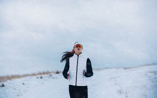 Landscape running places the woman in open winter snow during training