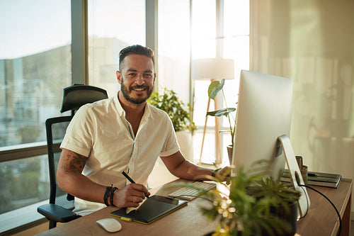 Creative young man working in office with graphic tablet