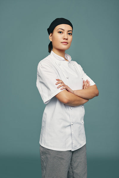 Confident female chef standing in a studio