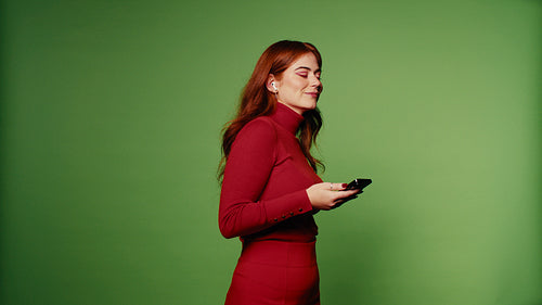 Happy young woman listening to music on smartphone