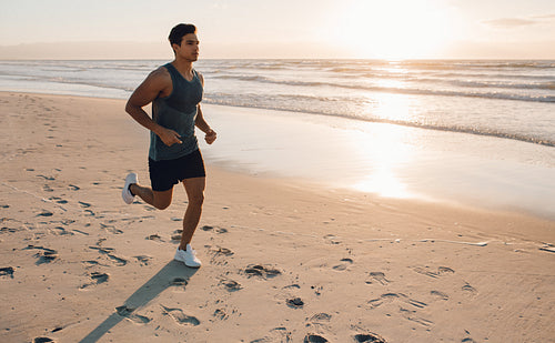 Young man training on the beach in morning
