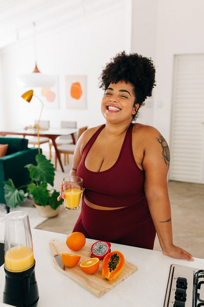 Healthy woman with glass of juice at home