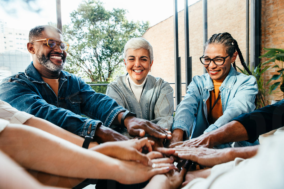 Multiethnic team showcasing teamwork with hands together in a positive ...