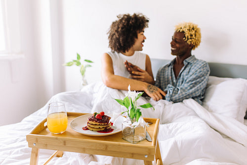 Couple sitting together in bed in the morning