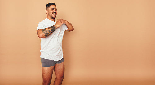 Young man taking his shirt off in a studio