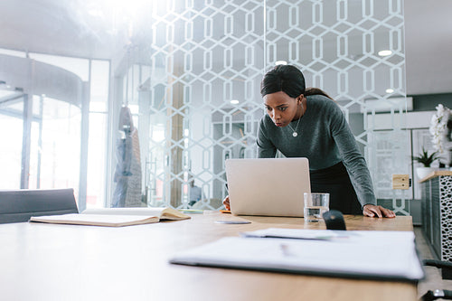 Businesswoman working on laptop in office boardroom