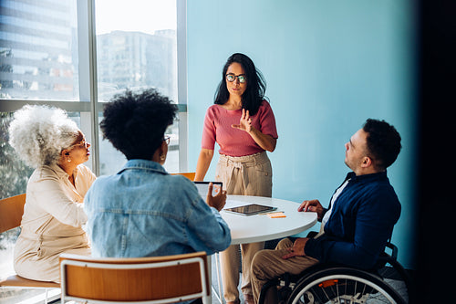 Explaining the plan: A young woman leading an inclusive discussion