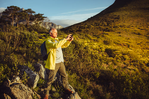 Hiker capturing the scenes from a hill top