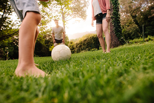 Family playing football in garden lawn
