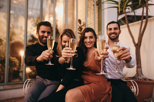 Glasses raised by a group of friends outside hotel
