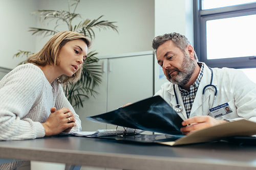 Doctor showing diagnosis of x-ray image to female