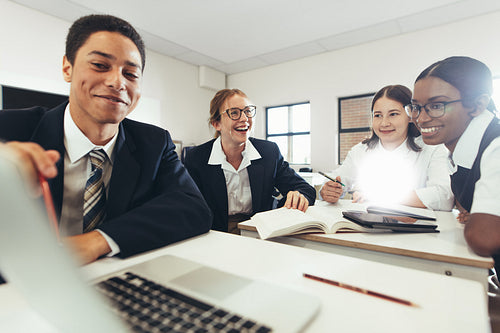 Group of student studying together on a laptop in classroom
