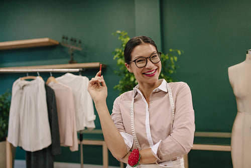 Smiling seamstress standing at her workshop