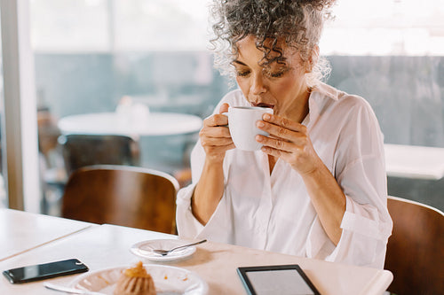 Mature businesswoman drinking coffee in a cafe