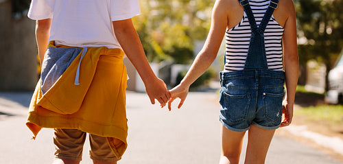 Kids in love walking on road holding hands