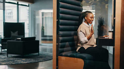 Young african entrepreneur smiling and waving during a successful online business meeting