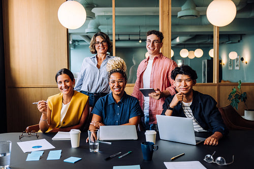 Diverse coworkers smiling together during a business meeting at the office