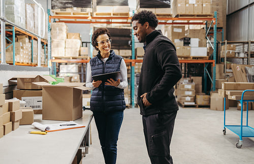 Warehouse manager showing a trainee how to do order fulfilment