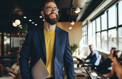 Happy businessman smiling in a co-working space