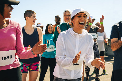 Diverse runners celebrating and supporting their community at a race event