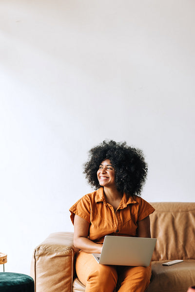 Pensive black businesswoman smiling happily in an office