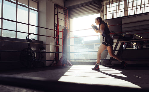 Female boxer training inside a boxing ring