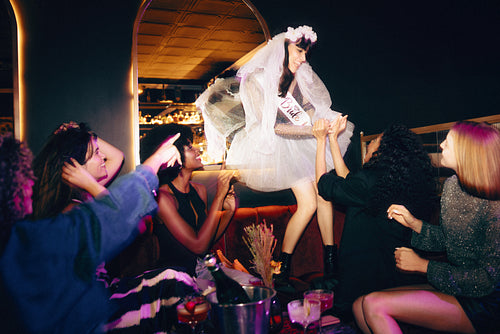 Bride and friends celebrating a lively bachelorette party at a festive venue