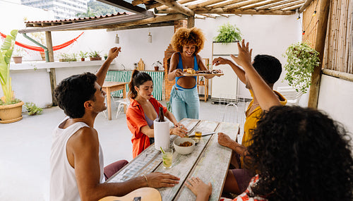 Friends enjoying outdoor lunch together on sunny Brazilian patio
