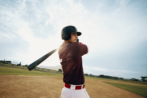 Baseball player executing a powerful swing on the field during a game