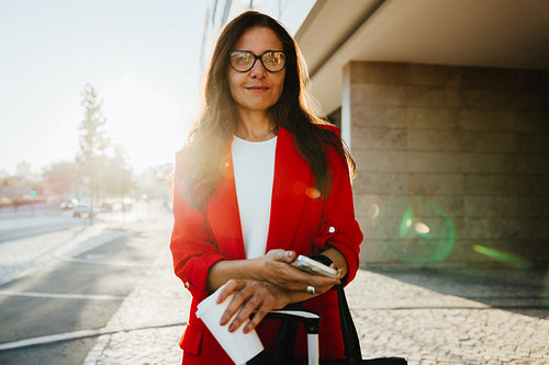 Businesswoman outdoors with tablet and coffee during business travel