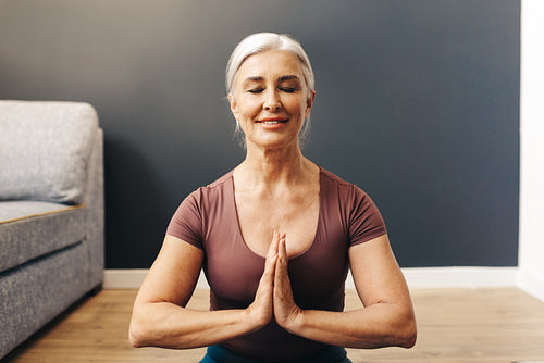 Peaceful woman meditating in prayer pose, connecting with her inner self
