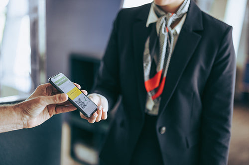 Flight attendant checking covid-19 passport of traveler