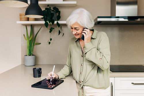 Experienced businesswoman taking an important phone call at home