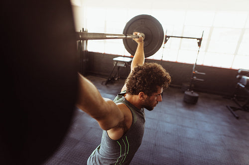 Muscular man exercising with barbell