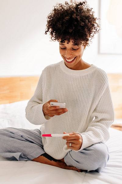 Young woman capturing her pregnancy test results at home