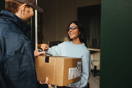 Woman receives a delivery package from a courier at the office entrance