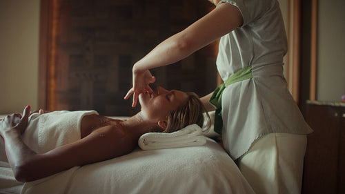 A beautiful woman receives a rejuvenating facial massage at a luxurious wellness spa resort