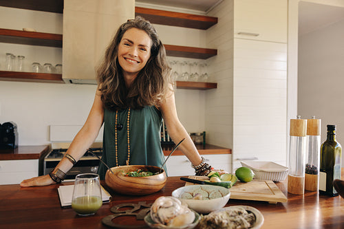 Healthy senior woman preparing some vegetarian food in her kitchen