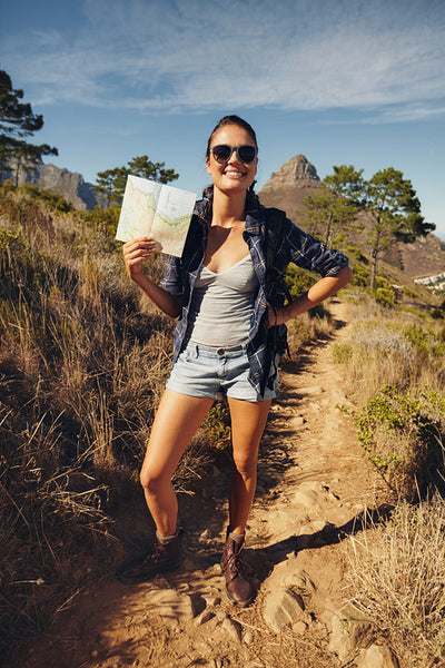 Beautiful woman hiker posing with a map