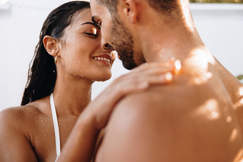 Young couple being romantic under an outdoor shower