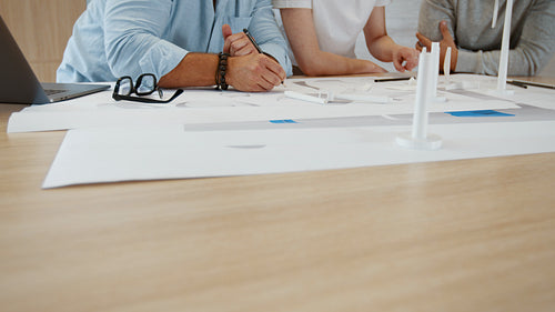 Teamwork in a mechanical engineering office: Three business people working on a wind energy project