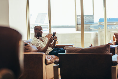 Man relaxing at home listening to music