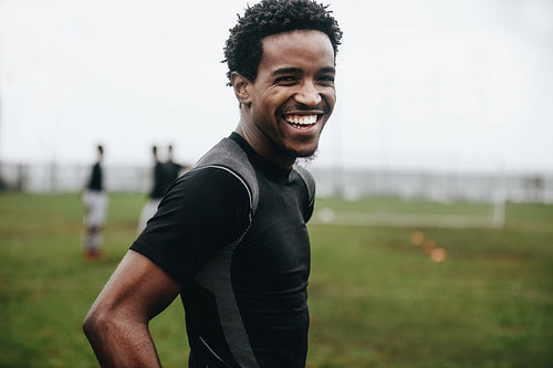 Close up of a smiling soccer player standing on field