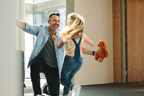 Girl running to greet her father returning from business trip