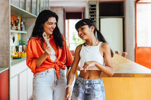 Happy mother and daughter spending quality time together in a bright kitchen