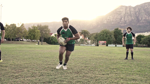 Rugby players tackling during match